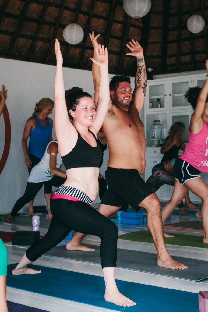 Beginner yogis learn to stand in Warrior I